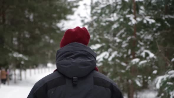 Young Man in Winter Forest Walking Drinking Hot Coffee