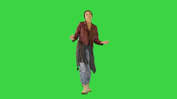 Young Girl in Stylish Urban Clothes Walks Dancing Slightly Snapping Fingers on a Green Screen Chroma