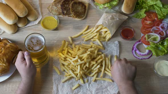 Man Pouring French Fries in Sauce and Drinking Beer Unhealthy Eating Calories