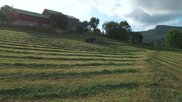 Agricultural Tractor With Hay Turner Attached Turning Grass For Silage Production In Norway. wide pa