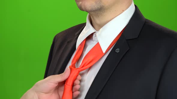 Woman's Hand Adjusts the Tie Around Her Servant's Neck. Green Screen. Close Up