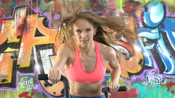 Woman Athlete Doing Intense Workout on Gym Bike.