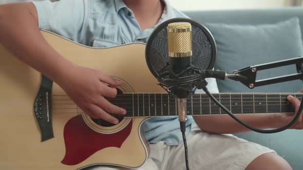 Close Up Hand Boy Playing Guitar. The Child Is Broadcasting Live On The Internet