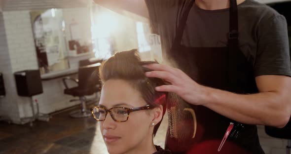 Male hairdresser styling customers hair