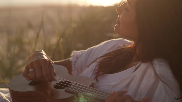 Woman With Ukulele During Summer Beach Vacation Near the Sea