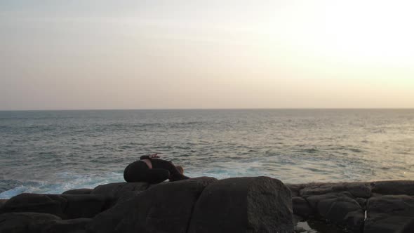 Girl Meditates in Yoga Pose Against Endless Blue Sea