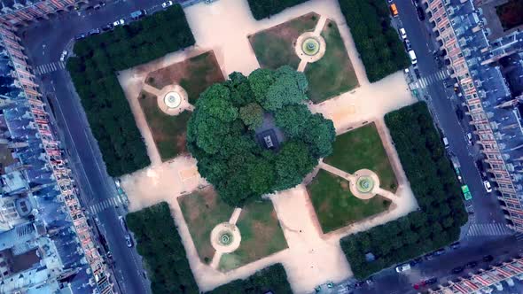 Rolling top down view of Place des Vosges from drone. Geometric shape of footpaths at symmetrical sq