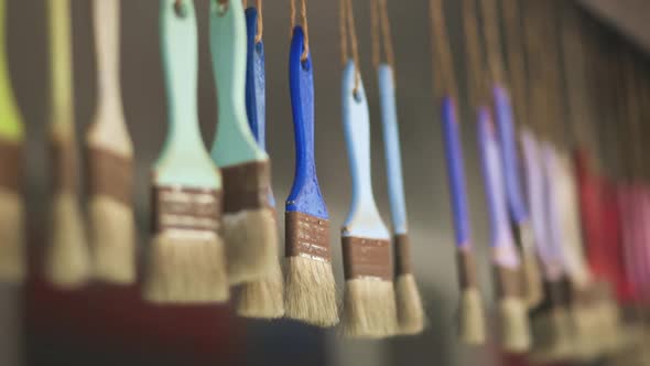 Many Colorful Brushes Hang on Ropes Close View