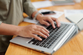 Selective focus on right hand of female employee and keyboard of laptop - PhotoDune Item for Sale