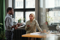 Young Muslim businesswoman listening to male colleague making report - PhotoDune Item for Sale