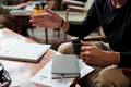 Hands of male economist with cup of tea during conversation with colleague - PhotoDune Item for Sale