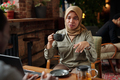 Young Muslim businesswoman in hijab having tea and talking to colleague - PhotoDune Item for Sale