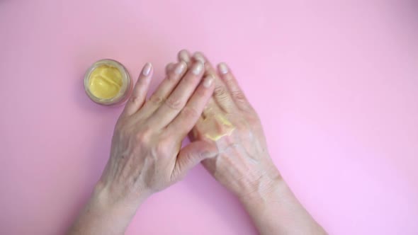 Woman Smears Her Hands with Cream