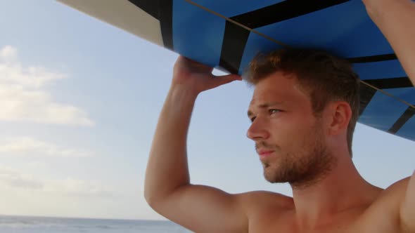 Man carrying the surfboard on his head at beach 4k