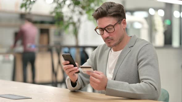 Middle Aged Man Successful at Online Payment on Smartphone