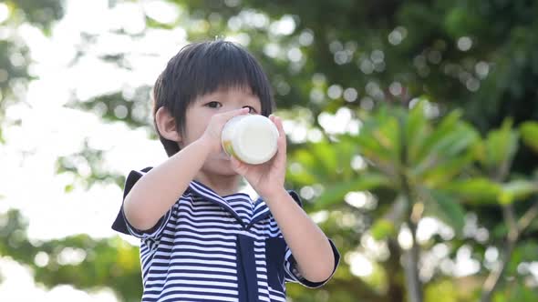 Cute Asian Child Drinking Milk And Licking Lips