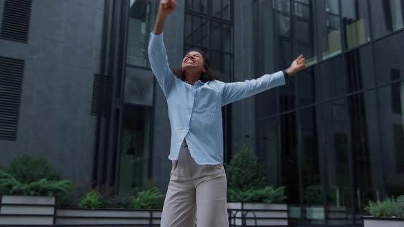 Happy Woman Celebrating Victory Dancing Alone on Modern Business Center Yard