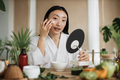 Beautiful healthy asian woman mixing mass in bowl while preparing cream and applying on face. - PhotoDune Item for Sale