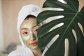 Portrait of beautiful young asian woman with green cosmetic mask on face and towel on head - PhotoDune Item for Sale