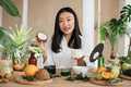 Young asian woman holding half of coconut and making homemade cream for healthy skin. - PhotoDune Item for Sale