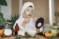 Portrait of beautiful young asian woman in towel and bathrobe removing green cosmetic mask - PhotoDune Item for Sale