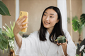 Close up portrait of ssian brunette shoulder length hair female social media influencer in bathrobe - PhotoDune Item for Sale