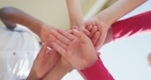 Video of diverse boys putting hands on each other in front of school