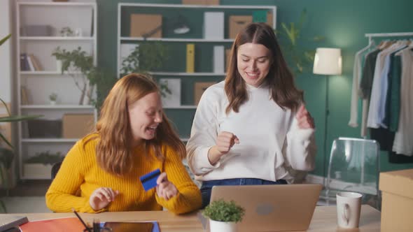 Joyful Girls Students Doing Shopping Together Online with aCredit Card From Home