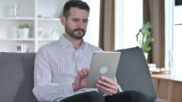 Serious Professional Businessman Using Tablet at Home