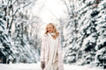 Fashion young smiling blonde woman in winter. Standing among snowy trees in winter forest.  - PhotoDune Item for Sale