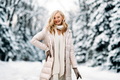 Fashion young smiling blonde woman in winter. Standing among snowy trees in winter forest.  - PhotoDune Item for Sale