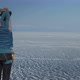 A Young Woman Makes a Warm-up Standing on the Shore of a Frozen Lake. - VideoHive Item for Sale