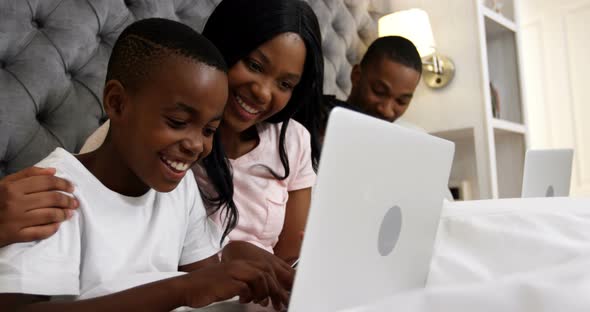 Family using laptop in bedroom 4k