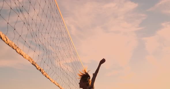 Sexy Volleyball Girls in Bikini Play on the Beach in Summer Volleyball on the Sand at Sunset in Slow