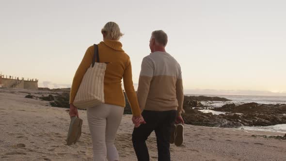 Senior couple holding hands at beach