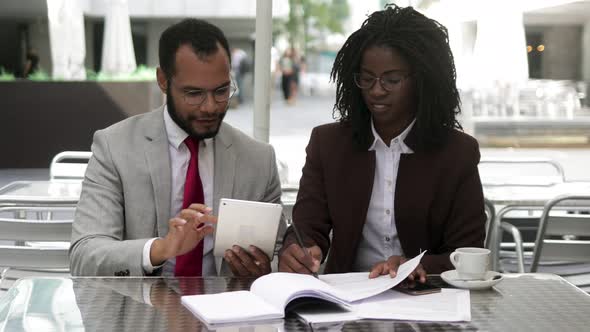 Successful Lawyers Talking While Sitting at Table with Documents