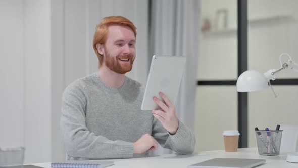 Video Chat on Tablet By Young Redhead Man