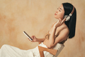 Calm relaxed asian female in headphones listening to classical music via app on phone - PhotoDune Item for Sale