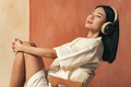 Side view of relaxed asian woman with wireless headphones, listening to meditation music - PhotoDune Item for Sale