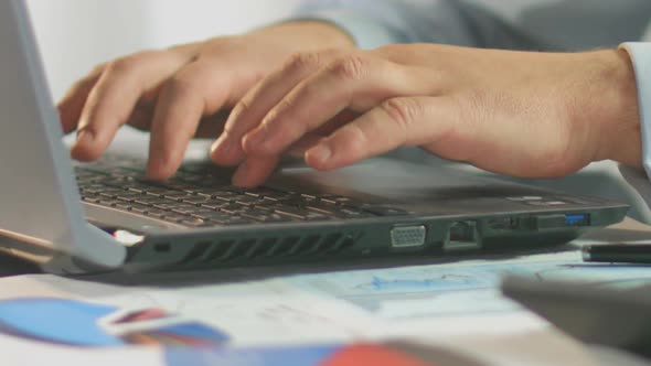 Businessman Typing Weekly Report on Laptop Computer, Close-Up of Male Hands