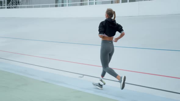 Woman with Artificial Limb Jogging on Track. Athlete Running on Sport Stadium