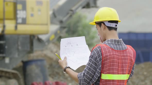 Construction Worker Working With Blueprint