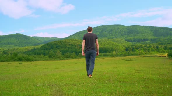 Back View Farmer Walking on the Meadow