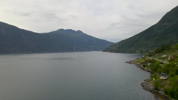 Aerial drone shot flying over Hardangerfjord and suspension bridge in Norway