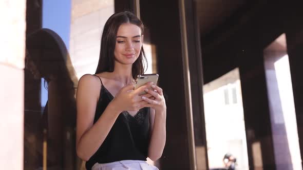 Beautiful Fashionable Woman Using Mobile Phone Near Office