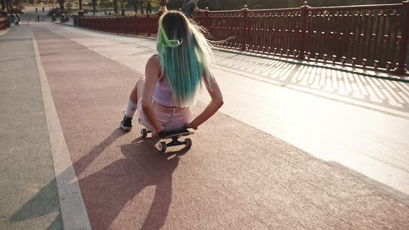 Porter of a Beautiful Young Girl with Blue Hair and a Bright Appearance Riding on a City Bridge