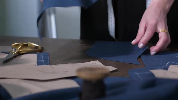 Dressmaker's Hands Laying Out Cut Pattern on Table