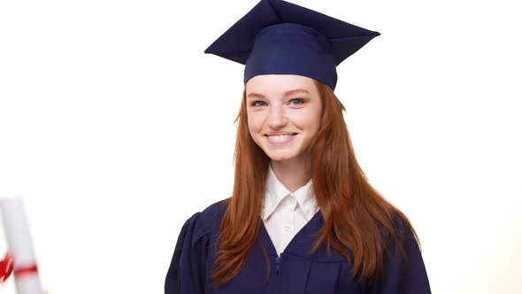 Happy Smiling Foxy Young Graduate Girl in Blue Academical Dress Entering Frame Holding Her Diploma