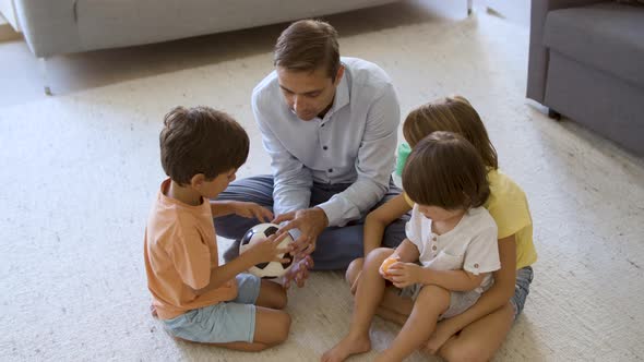 Dad Entertaining Sibling Children at Home