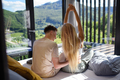 Rear view of young couple in love sitting on bed bed in morning in their new home in tiny house - PhotoDune Item for Sale